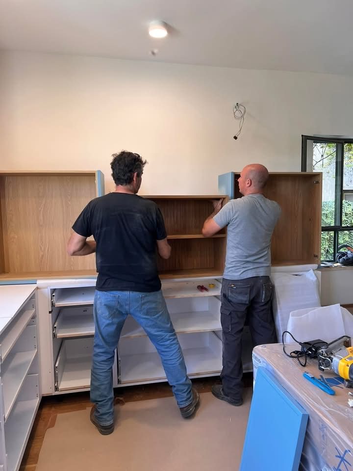 הצוות מתקין ארונות מטבח עליונים ותחתונים